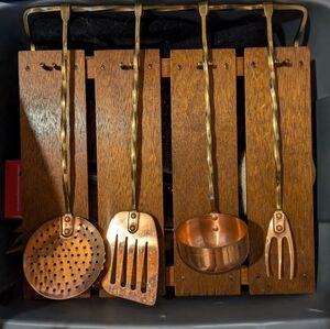 Vintage copper and brass cooking utensils with hanging board